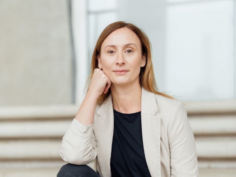 Diana Bluhm sitzt draußen auf einer Treppe