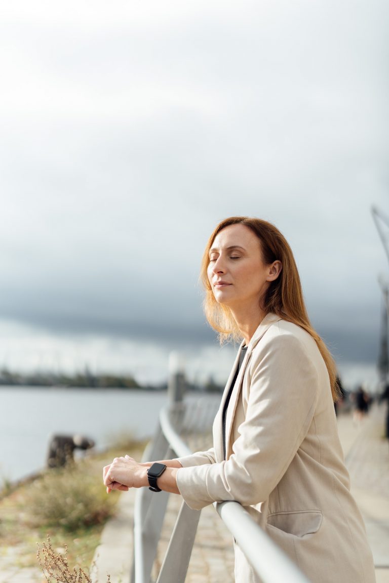 Diana Bluhm steht am Fluss und hat die Augen geschlossen