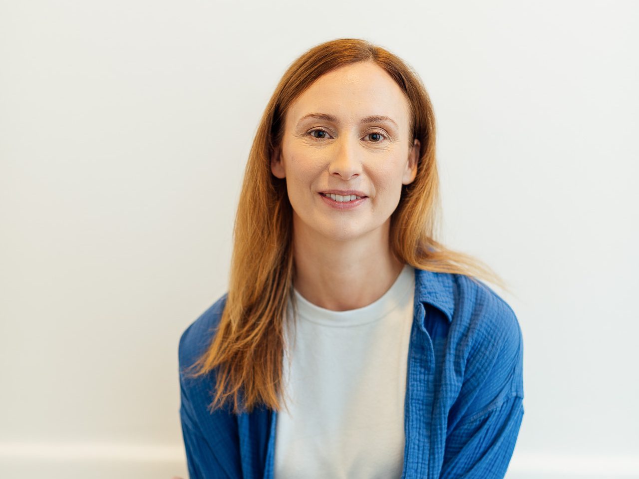 Diana Bluhm lehnt vor einer Wand und guckt in die Kamera