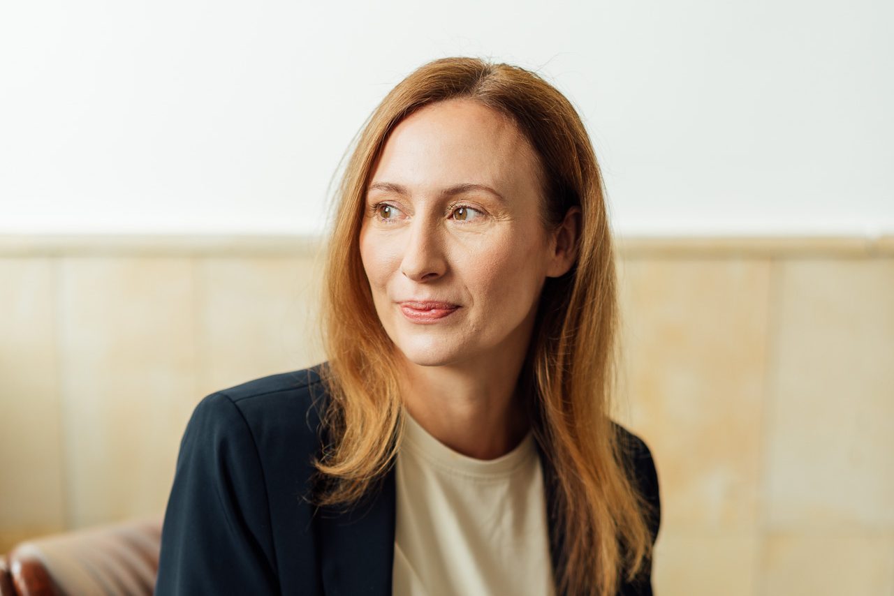 Diana Bluhm sitzt auf einem Stuhl und schaut raus